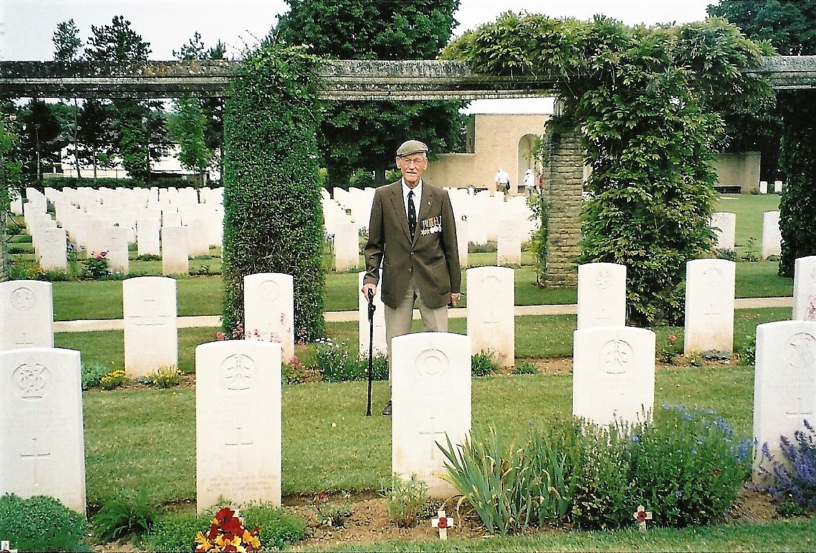2004. Felix Roland Johnson at Jesse Brook’s graveside.  Ranville Cemetery, nr. Caen, Normandy, France. Courtesy/© The Felix R. Johnson Collection.