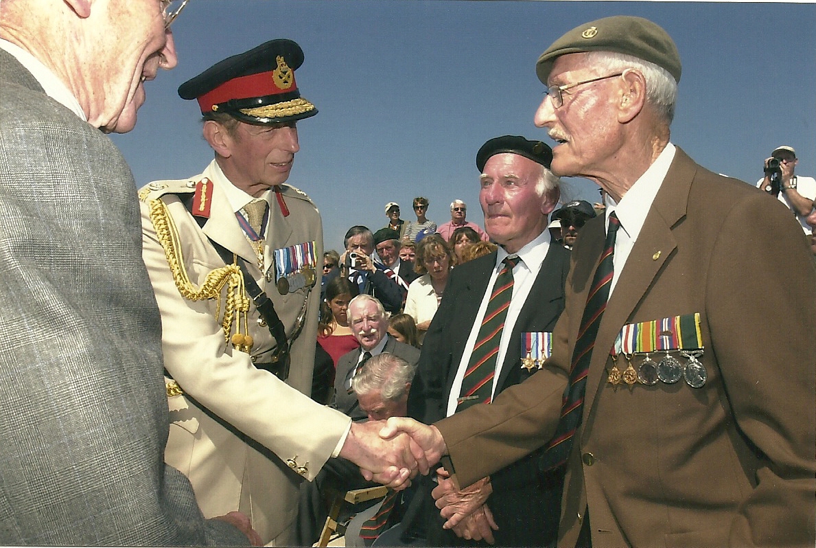 6 June 2004. Le Hamel Essex Yeomanry Memorial, Asnelles. Felix Roland Johnson meeting the Duke of Kent, with Fred Topping between. Courtesy/© The Felix R. Johnson Collection.